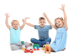 Cute little children playing with building blocks on white background