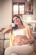 © liderina - Beautiful pregnant woman relaxing at her home with a cup of tea.
