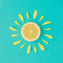 Sun Made Of Lemon And Yellow Flower Petals On Bright Blue Background. Fruit Summer Minimal Concept.