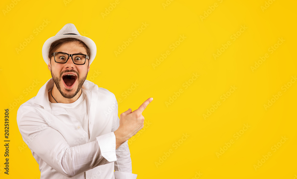 Happy hipster pointing up on yellow - obrazy, fototapety, plakaty 