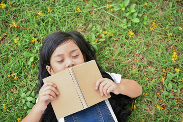 Education Concepts. The girl is reading a book in the garden. Beautiful girl is seriously studying. Beautiful girls are happy learning.