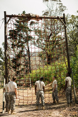 Wall Mural - Military soldier climbing rope during obstacle course