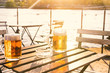 Two glasses of light beer with foam on a wooden table.On a boat. Garden party. Natural background. Alcohol. Draft beer. Landscape, golden.
