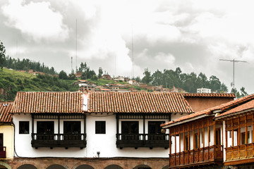 Wrought-wood balconies in front of the main square of Cusco (Peru) with hills in the background