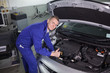 © WavebreakmediaMicro - Smiling mechanic leaning on a car with his thumb up