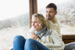 © WavebreakmediaMicro - Couple in winter wear looking out through cabin window