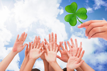 Poster - People raising hands in the air against bright blue sky with clouds