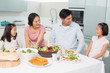 © WavebreakmediaMicro - Cheerful family of four enjoying healthy meal in kitchen