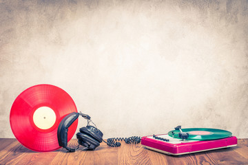 Wall Mural - retro dj turnable mixer, old headphones and red vinyl disc on wooden table. vintage style filtered p