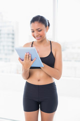 Poster - Lovely dark haired model in sportswear using a tablet pc