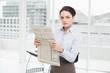 © WavebreakmediaMicro - Serious young businesswoman with newspaper in office