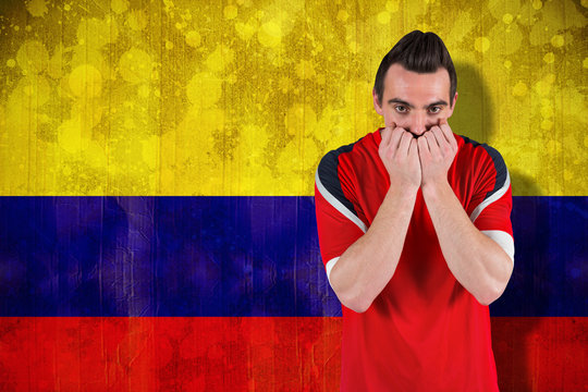 Nervous football fan looking ahead against colombia flag in grunge effect