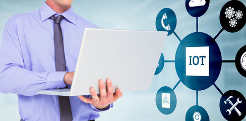 Poster - Businessman using a laptop against modern room overlooking city