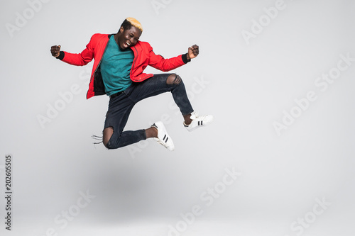 Full length portrait of a cheerful afro american man jumping isolated on a white Poster Mural XXL