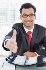 Poster - Businessman offering a handshake at office desk