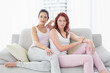 © WavebreakmediaMicro - Two serious beautiful female friends sitting in living room