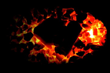 Poster - 
Bright burning charcoal anthracite on a black background.