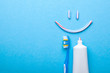 Tooth-paste in the form of face with a smile. Tube of the paste on blue background. Refreshing and whitening toothpaste. Copy space for text