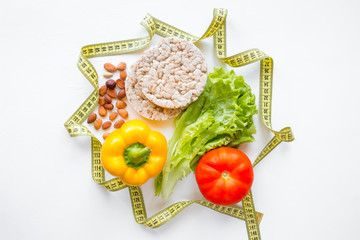 Wall Mural - measuring tape, vegetables and nuts on white background