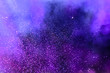 Confetti fired on air during a festival at night. Image ideal for backgrounds. Purple/magenta tonality. Smoke and lights in the middle of the multicolor confetti. Dark background as sky
