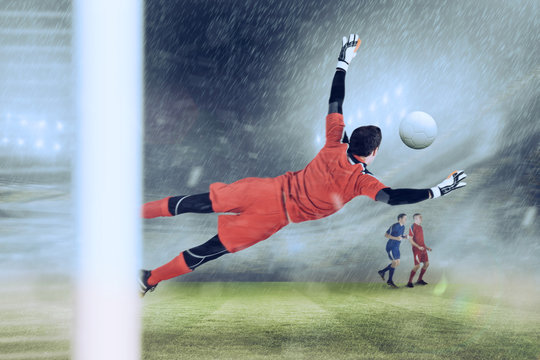 Fit goal keeper jumping up against football stadium