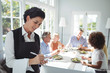 © WavebreakmediaMicro - Smiling waitress writing order in notepad