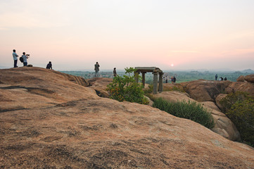 Wall Mural - Picturesque view from the Malyavanta Hill at sunset overcast sky in Hampi, Karnataka, India. Tourists enjoy and photograph the sunset