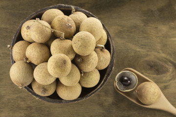 Wall Mural - Longan in a ceramic bowl on a background of wooden plywood