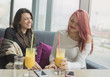 © Mateja88 - Portrait of two young beautiful women at coffee shop, girl talk.