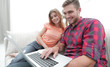© ASDF - Happy modern couple surfing the net and working on laptop at home