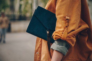 street style fashion details, chic blogger posing in trendy clothes. close up of a elegant handbag, suede leather purse. ideal fall or autumn outfit. 