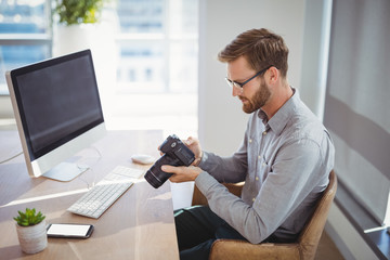 Aufkleber - Executive looking at digital camera at desk