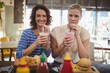 © WavebreakmediaMicro - Portrait of smiling female friends drinking milkshake while sitting at cafe