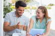 © WavebreakmediaMicro - Happy couple with coffee cup using digital tablet at cafÃƒÂ©