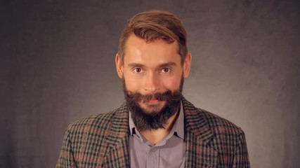 Leinwandbilder - young hipster man with beard posing on background in studio. handsome caucasian guy wearing casual shirt and trendy jacket. happy millennial looking at the camera and laughing