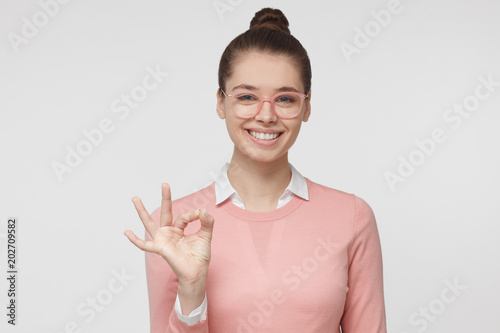 Cuadros en Lienzo Indoor headshot of young European Caucasian lady isolated on grey background wea