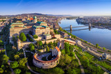 Budapest, Hungary - Aerial panoramic skyline view of Buda Castle Royal Palace with Szechenyi Chain Bridge, Hungarian Parliament and Matthias Church at sunrise with clear blue sky
