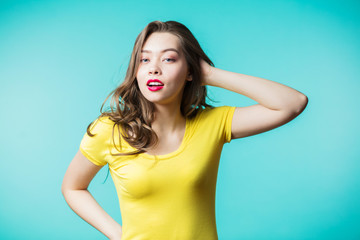 Wall Mural - Surprised young woman over blue background.