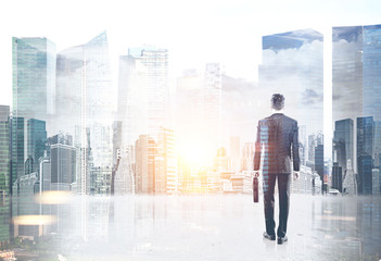 Canvas Print - Businessman with a suitcase against a cityscape