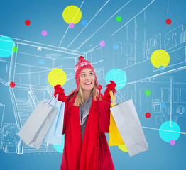 Wall Mural - Blonde in winter clothes holding shopping bags against blue vignette