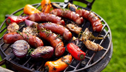 Wall Mural - Grilled sausages and vegetables on a grilled plate, outdoor. Grilled food, bbq