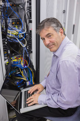 Aufkleber - Man typing on laptop while doing server maintenance