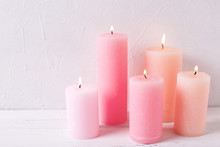 Pink  Burning Candles On White Textured Background.