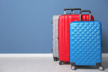 Different suitcases near color wall