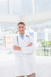 © WavebreakmediaMicro - Doctor smiling at camera with arms crossed