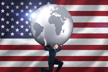 Businessman carrying the world against digitally generated american national flag