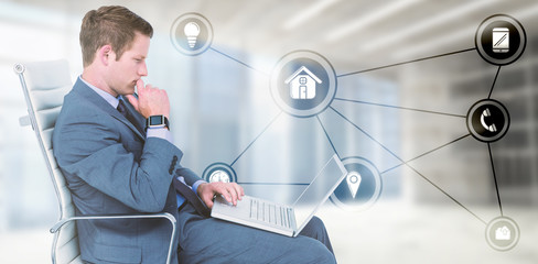 Poster - Handsome businessman using his laptop against modern room overlooking city