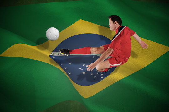 Football player in red kicking against white leather football with shadow