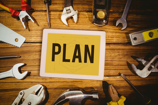 The word plan and tablet pc against blueprint