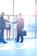 Wall Mural - Full length image of two successful business men shaking hands with each other